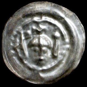Brakteat „ratajski”, Głowa władcy w hełmie z krzyżem po bokach proporzec i buława, monetę przypisano Henrykowi Bro...