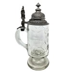 A glass mug with an ornate pewter lid and a figure of Germania
