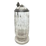 A glass mug with a floral design and a crystal-cut lid