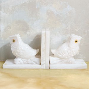 A set of two bookends decorated with an owl motif, made of white marble.