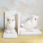 A set of two bookends decorated with an owl motif, made of white marble.