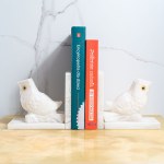 A set of two bookends decorated with an owl motif, made of white marble.