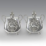 Pair of silver-plated pewter jars with two handles, featuring a smooth body decorated with a lion holding a ring and animal-shaped feet