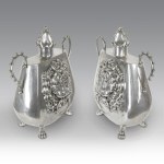 Pair of silver-plated pewter jars with two handles, featuring a smooth body decorated with a lion holding a ring and animal-shaped feet