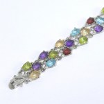 A three-row silver bracelet with natural topaz, peridot, garnet, amethyst, and citrine