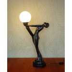A large ceramic lamp in the Art Deco style—a woman holding a lantern.