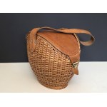 Vintage-style hand-woven wicker bag with a leather flap and handle—1970s