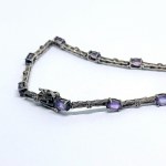 A thin silver bracelet with natural amethysts