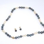 A gold set featuring freshwater pearl earrings and a necklace