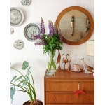A large round wall mirror in a teak frame, from Denmark. 1970s/1980s.