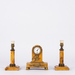 A yellow marble triptych consisting of two candlesticks and a small table clock
