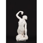 White porcelain sculpture depicting a nude woman holding a bunch of grapes