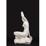 White porcelain sculpture depicting a nude woman holding a bunch of grapes