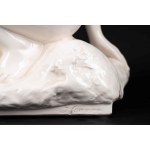 White porcelain sculpture depicting a nude woman holding a bunch of grapes
