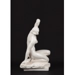 White porcelain sculpture depicting a nude woman holding a bunch of grapes