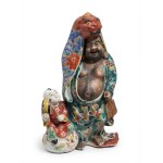 Kutani porcelain okimono depicting a male figure wearing a Shishi mask and a child, 25 cm.