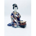 Polychrome porcelain figurine depicting a musician with a shime-daiko drum; height: 19 cm.