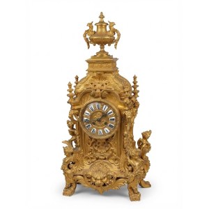 Monumentální krbové hodiny ze zlacené bronzu s okřídlenými sfingami z daného období. Rozměry: 70 × 34 cm.