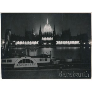 cca 1930-1940 Szendrő István (1908-2000): Budapest, a kivilágított Parlament éjjel, előtte a Báttaszék (Bátaszék) lapátkerekes gőzhajó, a hátoldalon pecséttel jelzett fotó, kisebb szakadással, 17×23,5cm