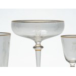Crystal glass set with gold trim and an engraved crowned monogram.