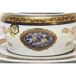 Two-handled porcelain soup tureen with a plate featuring blue and gold trim and leaf swirls. Limoges.