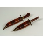 A roasting set consisting of a carving fork and knife in a dagger-shaped case, carved from wood with floral motifs and metal. Made in India, 20th century.