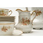 Tea set with gold handles and trim, made of white porcelain and decorated with red flowers. M. Redon, Limoges.