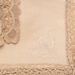 Rectangular Burano lace tablecloth featuring rich floral motifs on a mesh background. Includes twelve napkins.