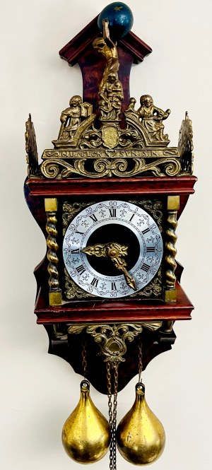 Dekoracyjny zegar ścienny zdobiony figurą Atlasa