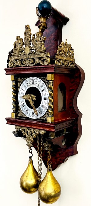 Dekoracyjny zegar ścienny zdobiony figurą Atlasa