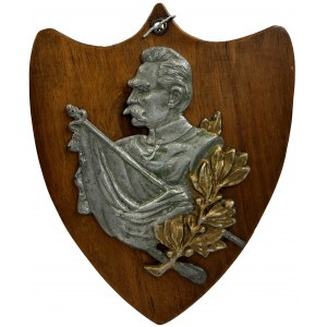 Plaque with the image of Józef Piłsudski against the background of a banner