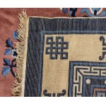 A PINK GROUND CARPET WITH A POLYCHROME DECORATION OF CHARACTERS, SYMBOLS AND STYLIZED FLORAL MOTIFS