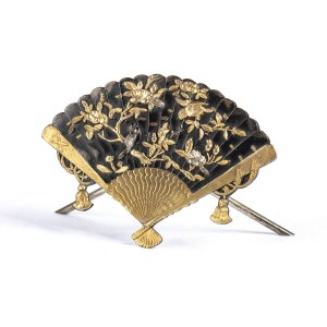 A PARTIALLY GILT METAL FAN-SHAPED CARD HOLDER WITH A RELIEF DECORATION OF A BIRD AND FLOWERS
