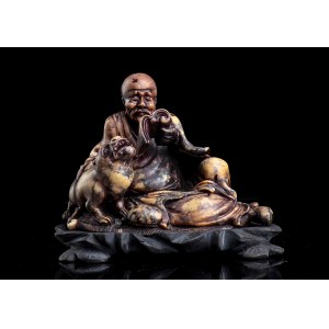 A SOAPSTONE SCULPTURE OF A LOHAN AND TIGER
