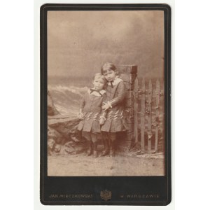 VARŠAVA - Mieczkowski. Portrét dvoch detí, kartón, okolo roku 1880; fotografický frontispice, signovaný JAN MIECZKOWSKI vo VARŠAVE a dvojhlavý orol, na verso dekoratívny reklamný odtlačok fotografickej dielne, adresy jej ateliéru: Miodowa ulica vo Varšave