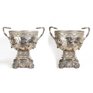 Impressive pair of Peruvian silver two-handled vases - early 20th century, of classical style, entirely embossed and chiselled with olive branches and resting on a base with four double scroll feet interspaced with shells. Sterling silver. Base with woode