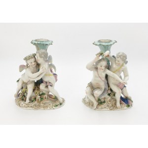 A pair of candle holders with cupids