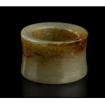A GREEN AND RUSSET JADE ARCHER'S RING China, 20th century