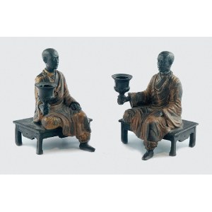 Para lichtarzy z siedzącymi mnichami buddyjskimi