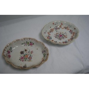 CHINE Ensemble de deux petits plats en porcelaine blanche à décor polychrome de fleurs. Long.: 18 cm