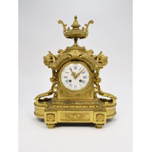 Mantel clock topped with a vase