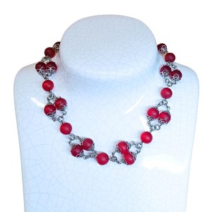 Collier de perles rouges dans une monture décorative