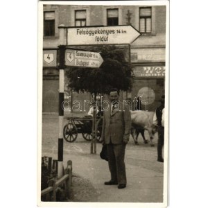 ~1940 Dés, Dej ; utcakép, férfi kalappal az útjelző tábla alatt, mögötte ökrös szekér / street view, man with hat...