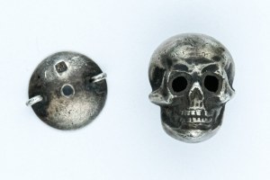 Badge in the form of a skull