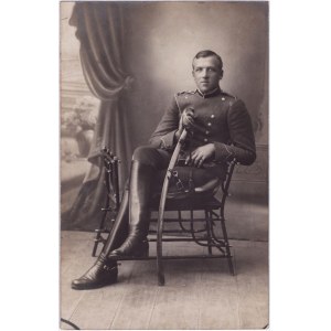 Fotografia di ritratto di un ufficiale seduto in uniforme con una sciabola