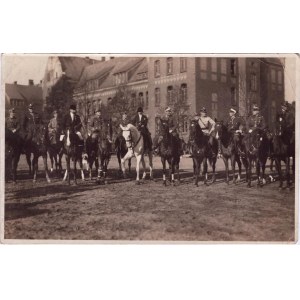 Skupinová fotografia policajtov na koňoch pred budovou