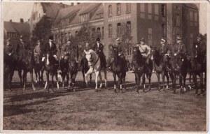 Skupinová fotografie policistů na koních před budovou