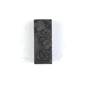 Motyw dekoracyjny kwiatowy (secesyjny). Klisza form. 3,6x1,4 cm na podstawie drewnianej.