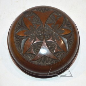 A wooden box, black, carved with floral motifs.