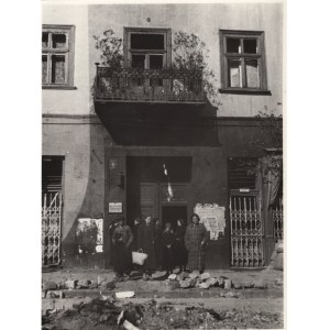 People's Republic of Poland, Warsaw (?) - Photograph of a Group of People in the Background of a Tenement Amidst War Destruction; Advertising Business Card of an Accoucheurist, Notices on the Facade - Late Print